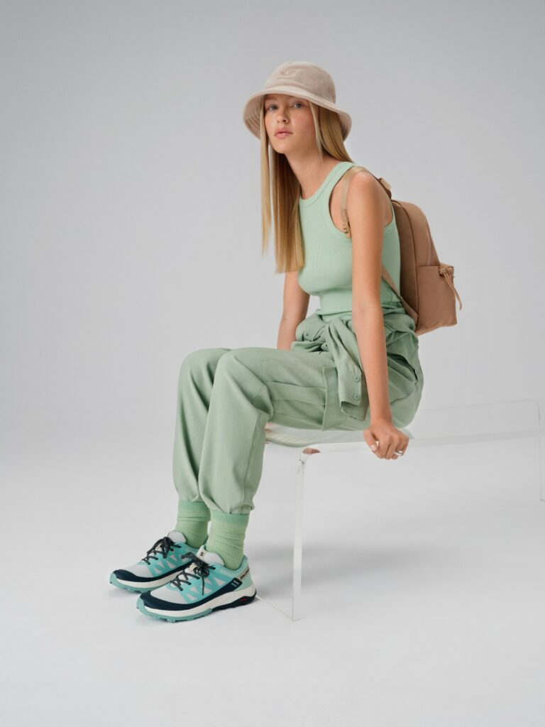 Modelka oblečená ve streetwearovém stylu: béžová čepice adidas a boty Salomon
