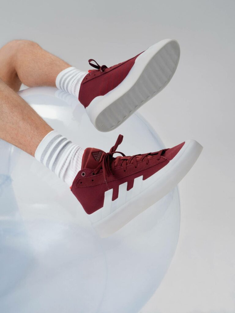 Červené vysoké tenisky adidas a bílé sportovní ponožky
