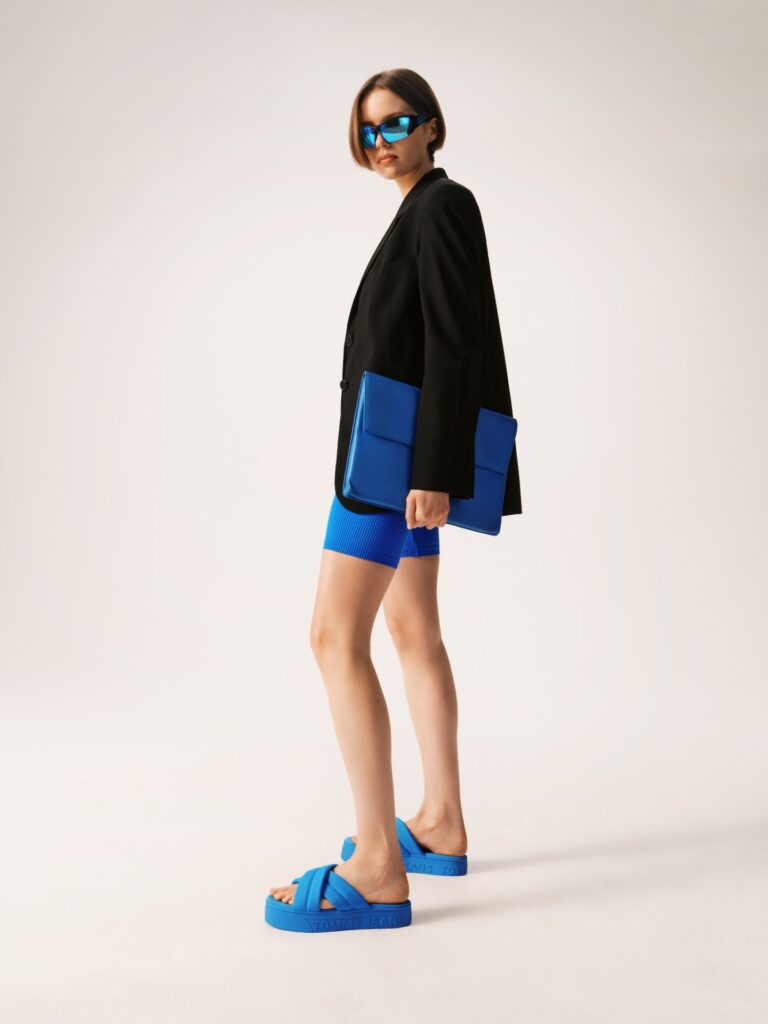 Stylizace s černým sakem a ladícími modrými šortkami a žabkami na platformě ve stejné barvě.