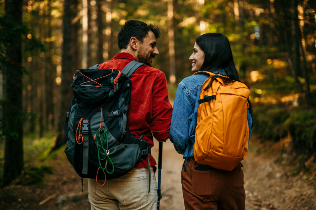 muž a žena na túře v horách, vybaveni turistickými batohy