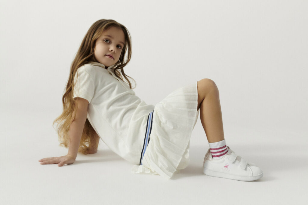 Dívka v outfitu Beverly Hills Polo Club: sukně, polokošile a polobotky